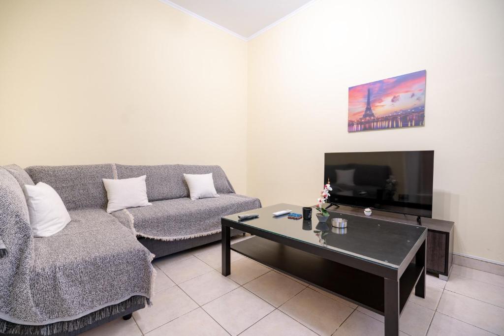 アテネにあるNeos kosmos 1 bedrm semi-basement flat by MPSのソファとコーヒーテーブルのあるリビングルーム