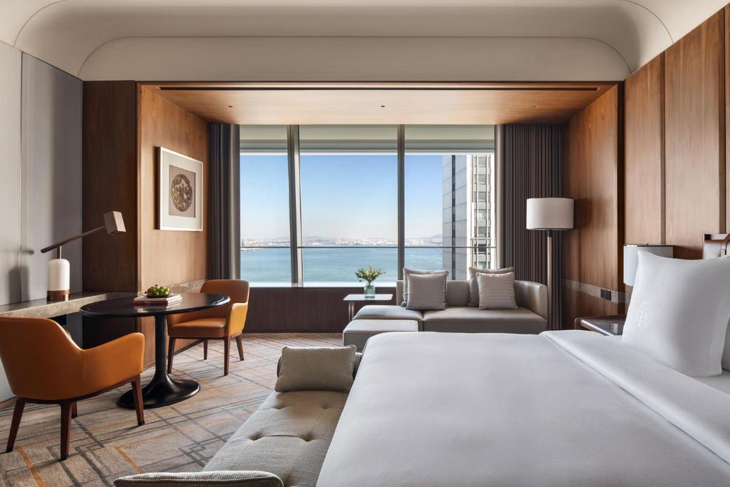 a hotel room with a bed and a living room at Four Seasons Hotel Dalian in Dalian