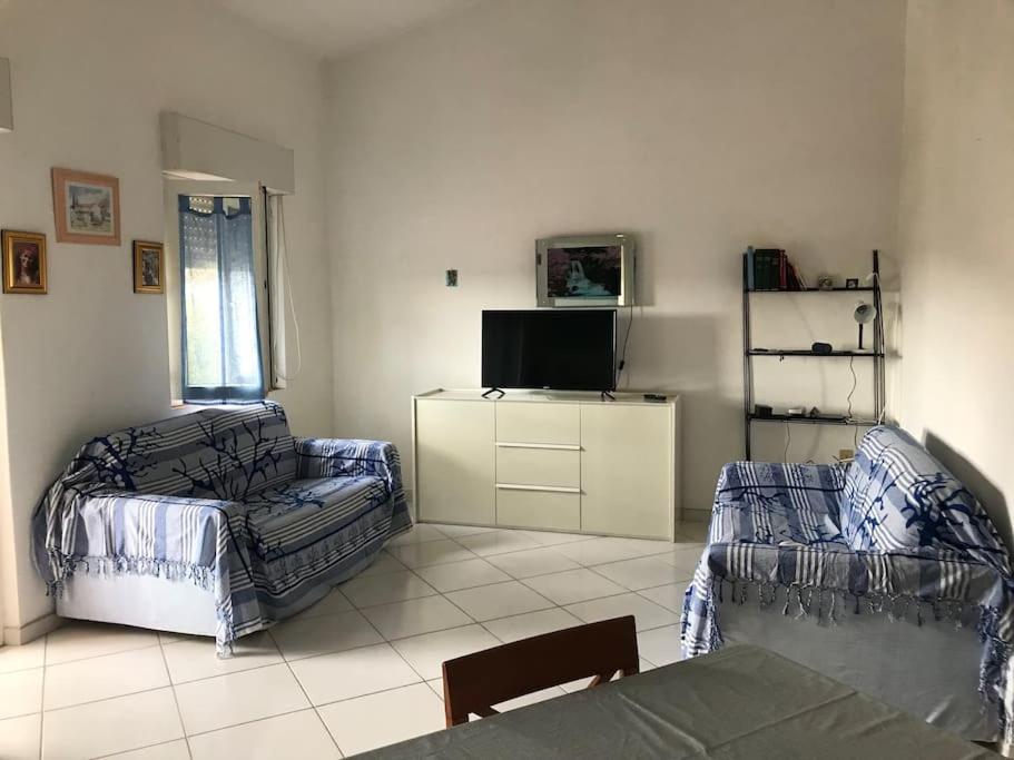sala de estar con sofá y silla en Comfort Home, en Capoterra