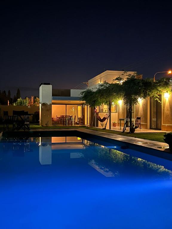 a man is in a hammock by a swimming pool at night at Madame Chacras in Chacras de Coria