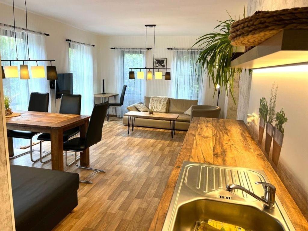 a kitchen and living room with a table and a couch at Geräumige Wohnung in Bad Elster mit Terrasse, Garten und Grill in Bad Elster