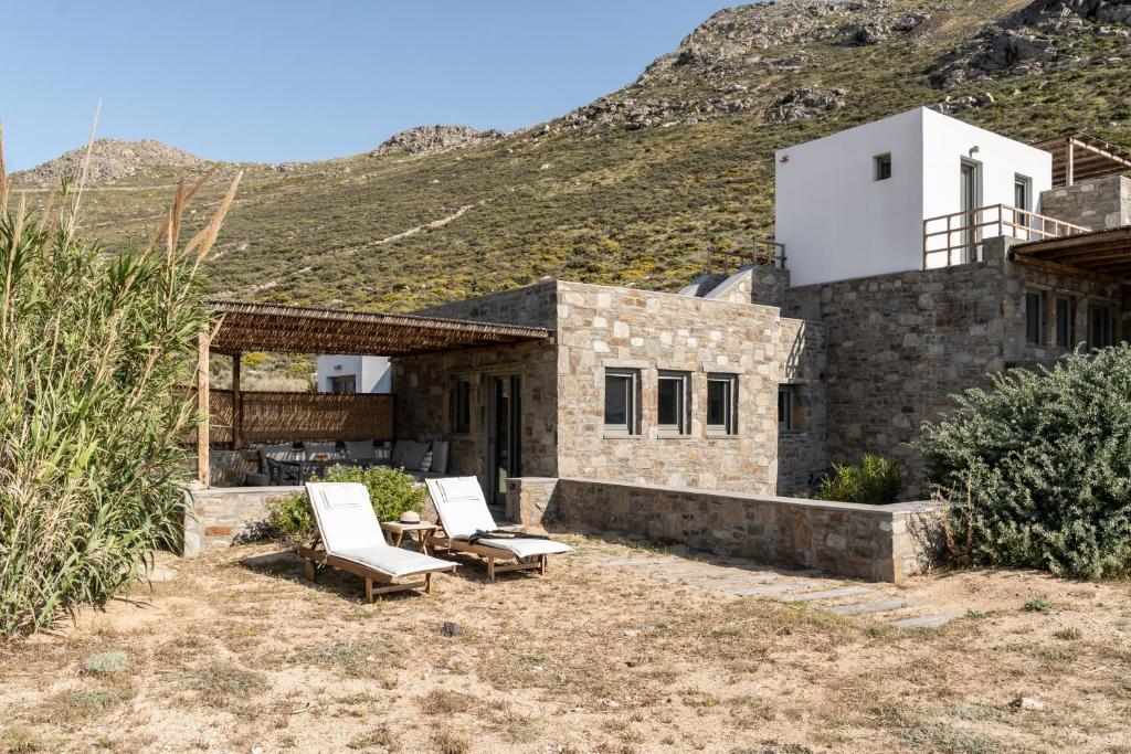 a stone house with two lounge chairs in front of it at Ammoa Beach Residences in Vayiá