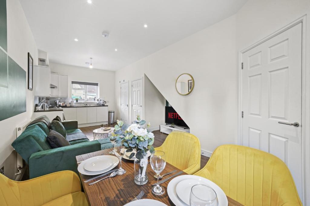 a living room with a table and yellow chairs at 124 Vere Road in Peterborough