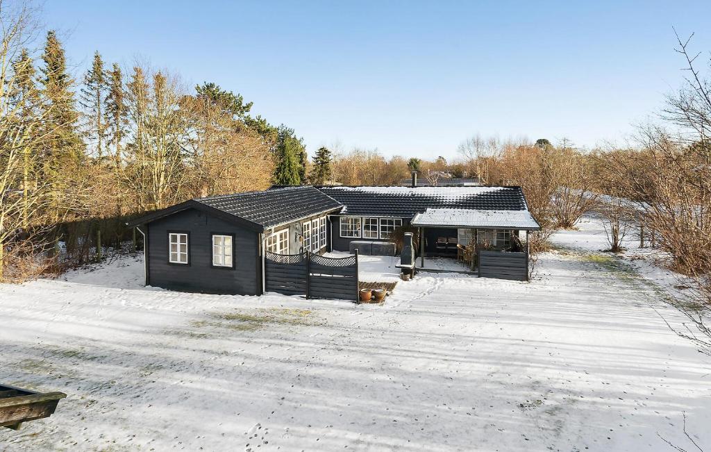 ein schwarzes Haus mit Schnee auf dem Boden in der Unterkunft Beautiful Home In Gilleleje With Wifi in Gilleleje