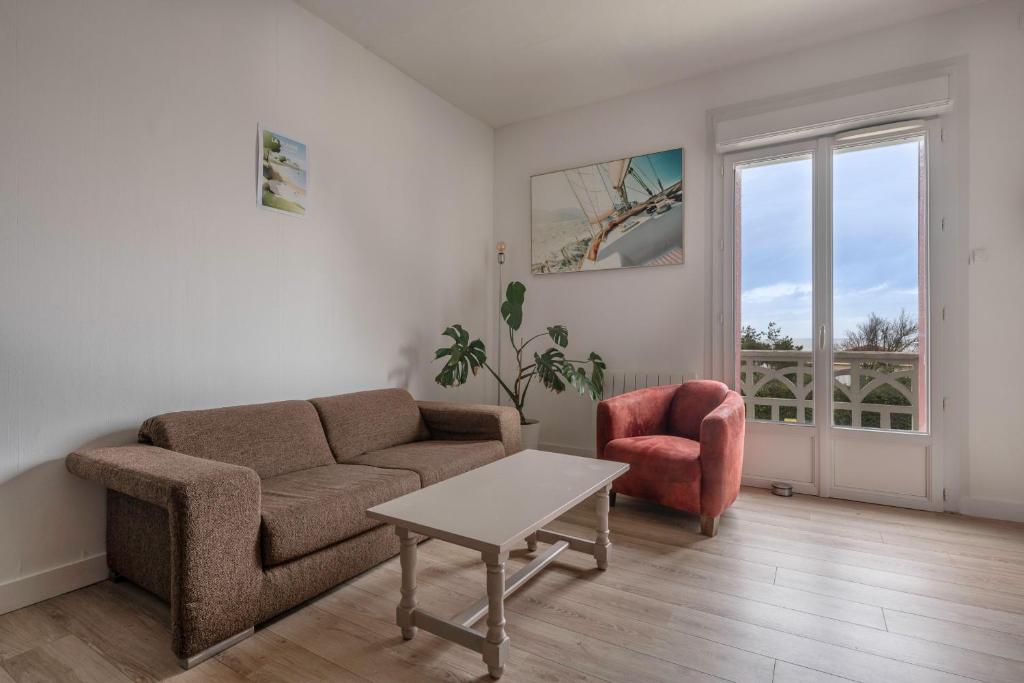 - un salon avec un canapé, une chaise et une table dans l'établissement À 50m de la plage, Appartement vue mer, à La Plaine-sur-Mer
