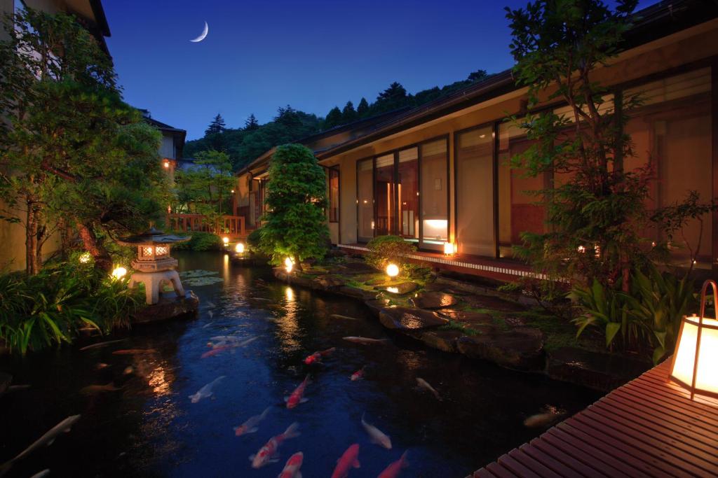 a hotel with a pond with kites in it at night at Ryokusuitei in Kamogawa