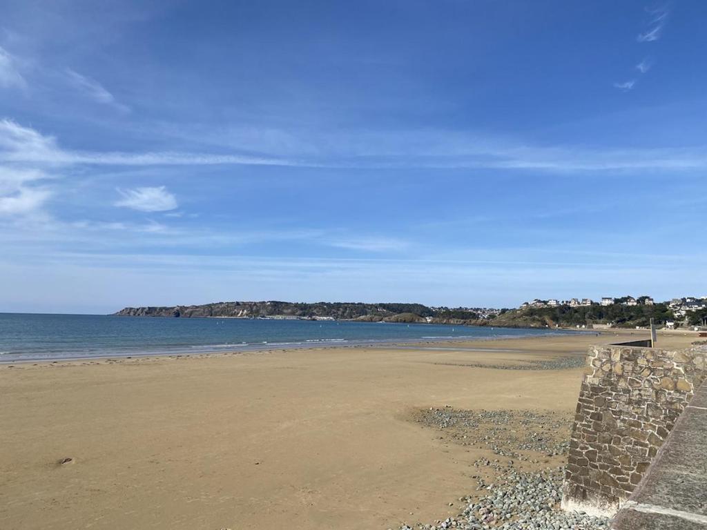 Elle offre une vue sur une plage avec l'océan et le ciel. dans l'établissement 470 - Appartement accès direct à la très belle plage de CAROUAL 2km de sable fin, à Erquy