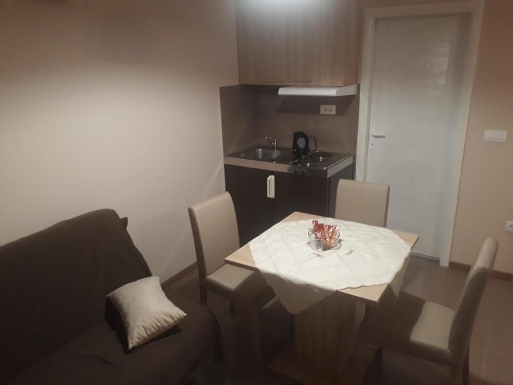 a small room with a table and chairs and a kitchen at Apartmani J&J in Šabac