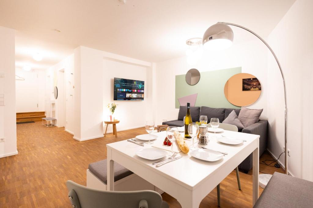 uma sala de jantar branca com uma mesa e cadeiras brancas em Ko-Living - Yellow Submarine Suite - Altstadt - Küche - 2 SZ - getrennte Betten - bis 7 Gäste em Halle an der Saale