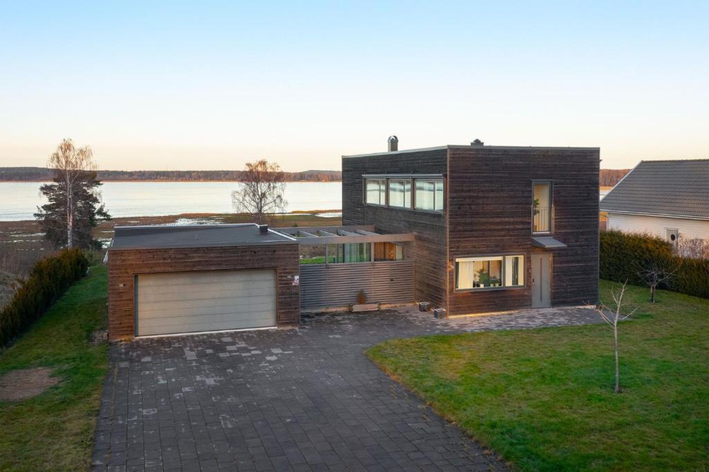 une maison avec un garage et un lac dans l'établissement Nyköping Villa: Serene & Stylish, à Nyköping