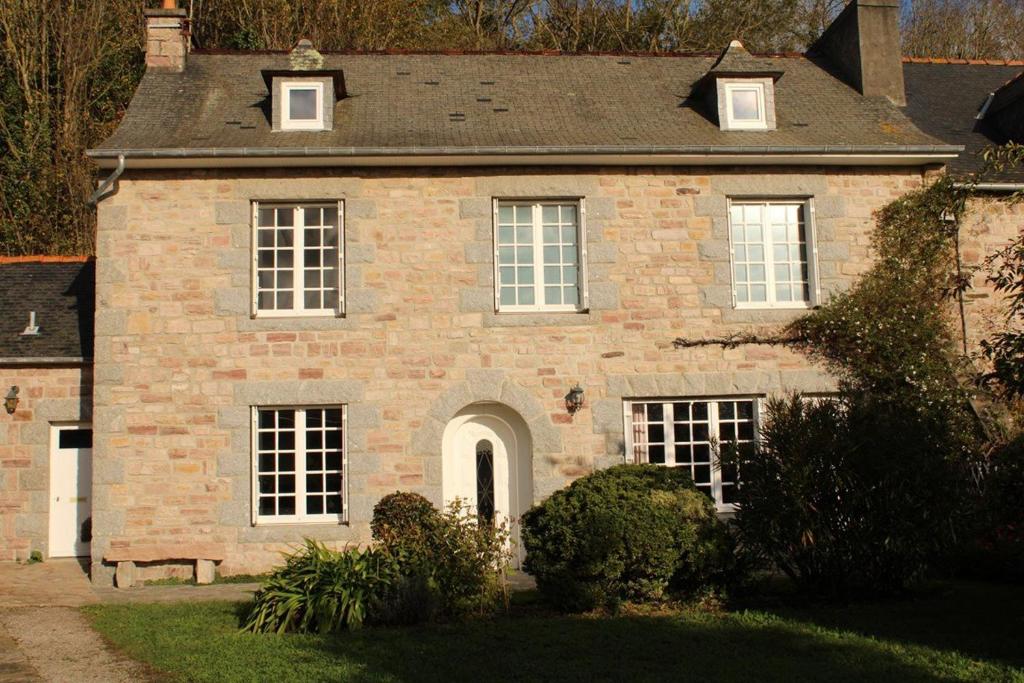 Cette grande maison en briques est dotée de portes et de fenêtres blanches. dans l'établissement 503 - Belle maison à Erquy à proximité du port et face à la plage, à Erquy