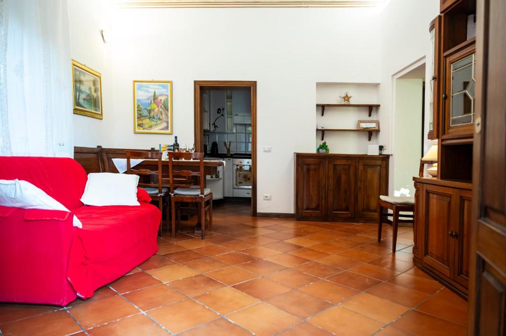 - un salon avec un canapé rouge et une table dans l'établissement Casa degli Affreschi Tuscany, à San Rocco a Pilli