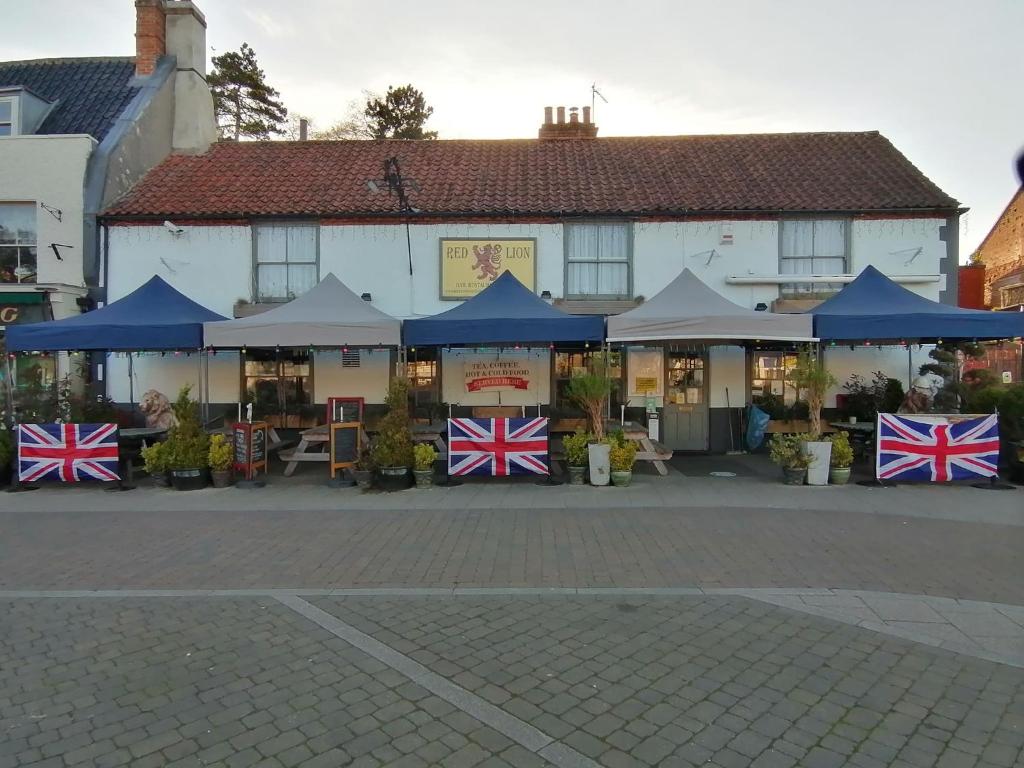 un edificio con banderas británicas delante de él en Red Lion, en Swaffham