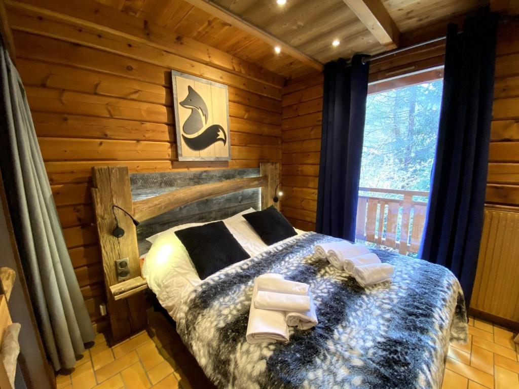 a bedroom with a bed in a log cabin at LE RENARD Chalet en bois in La Bresse