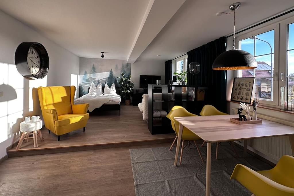 uma sala de estar com cadeiras amarelas e uma mesa em Urban Apartments Weimarer Land em Buttelstedt