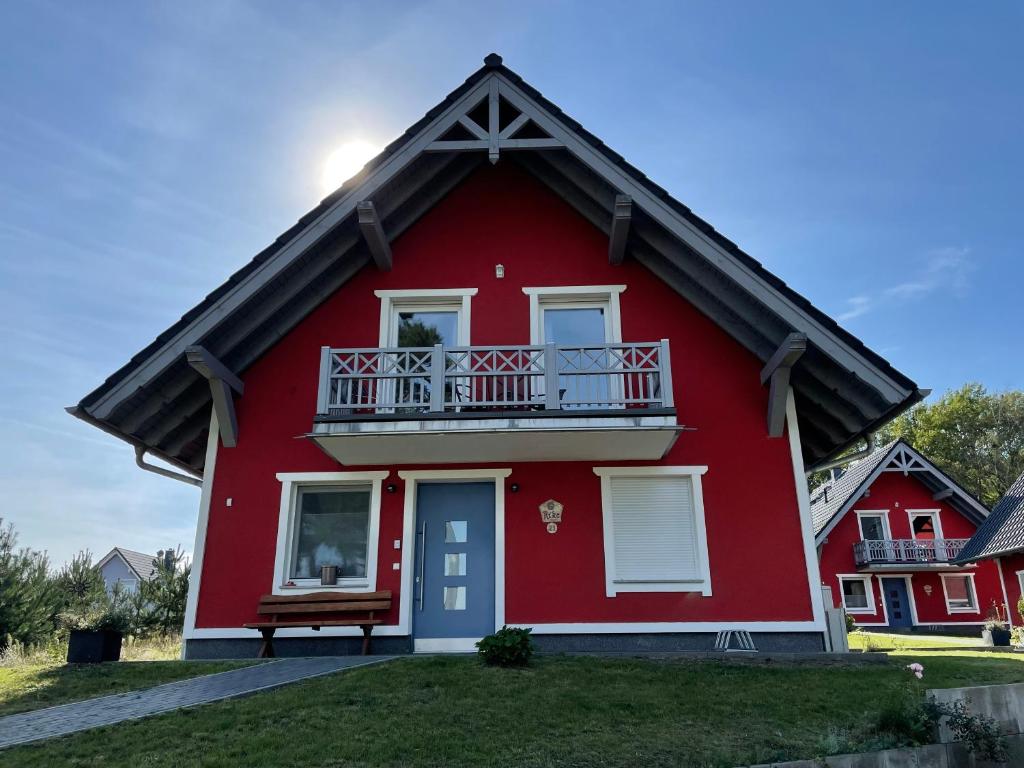 a red house with a balcony on top of it at Urlaub am Plätlinsee Haus Rike in Wustrow