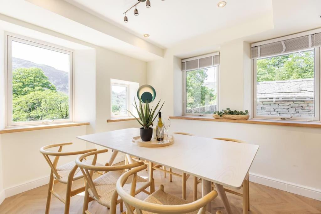 a dining room with a white table and chairs at Langdale Boulders, Ambleside, Fantastic views in Chapel Stile