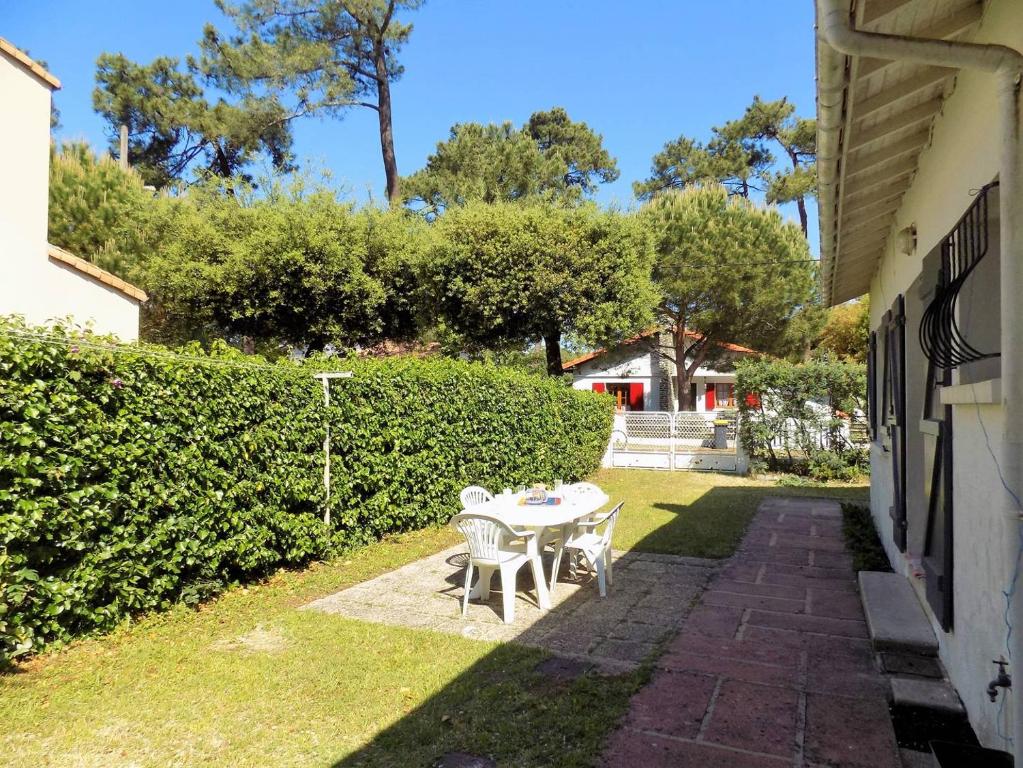 - une table et des chaises dans la cour d'une maison dans l'établissement Ronce-les-Bains - MAISON MITOYENNE avec son JARDIN PRIVATIF - AU CALME et SOUS LES PINS, à Ronce-les-Bains