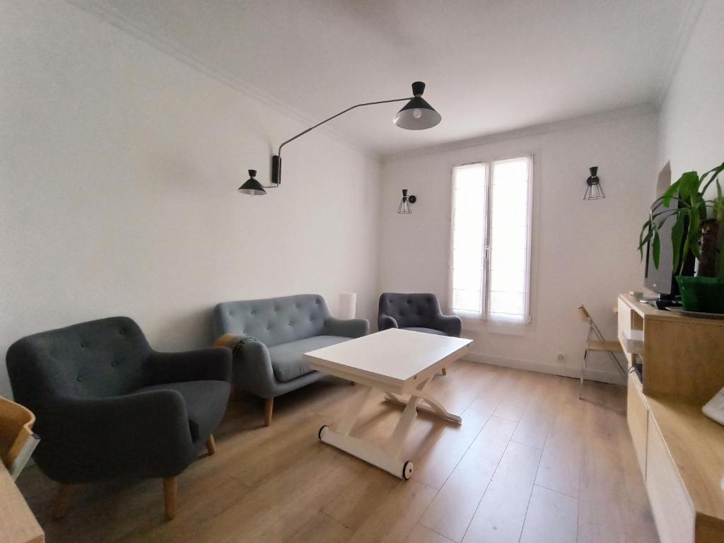 a living room with two chairs and a table at Home Rental Service in Paris