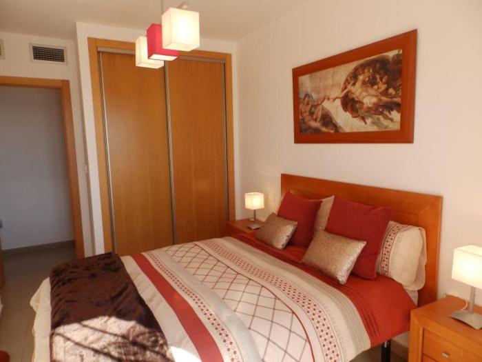 a bedroom with a large bed with red pillows at MH38 - Apartment with wonderful sea views in Murcia