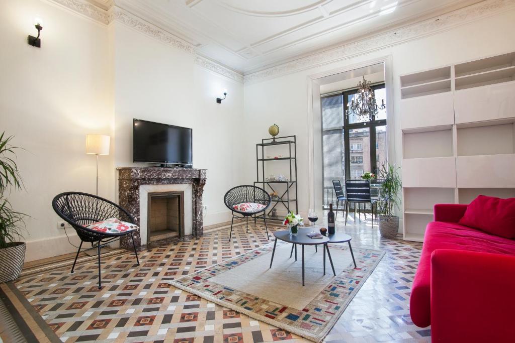 sala de estar con sofá rojo y chimenea en Tendency Apartments 6, en Barcelona