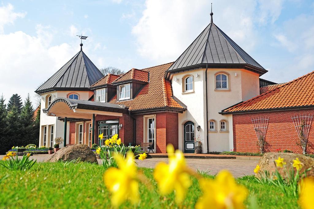 a large house with two towers with yellow flowers at Landgut Stemmen in Stemmen