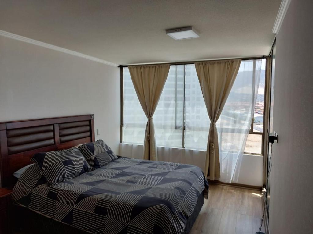 a bedroom with a bed and a large window at El Faro Antofagasta in Antofagasta