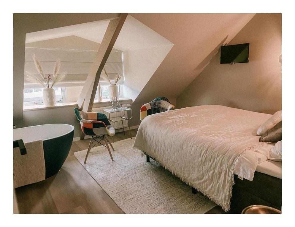 a bedroom with a bed and a desk and a chair at Slapen op Tholen in Tholen