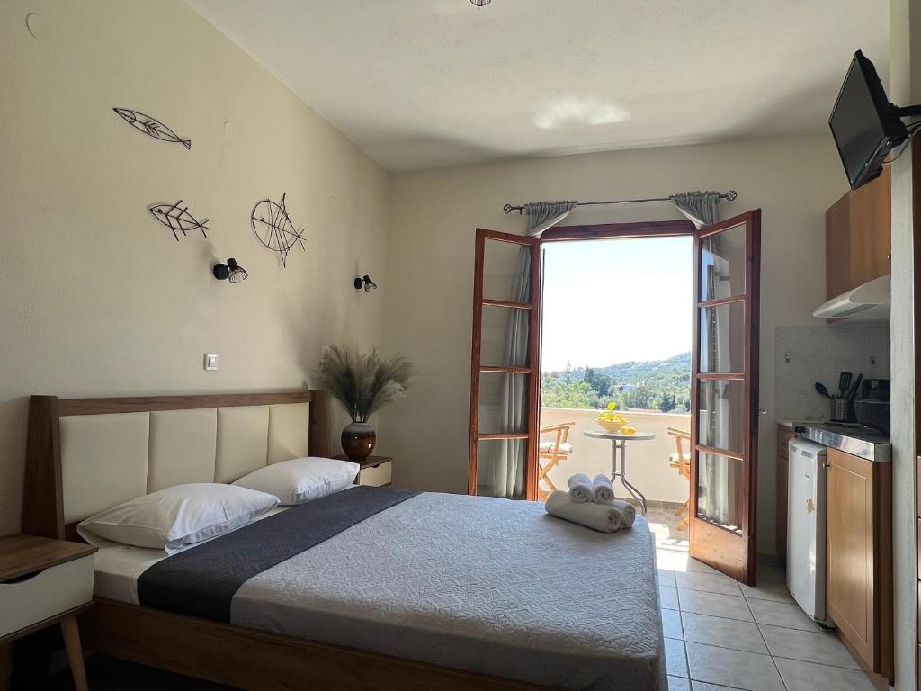 una camera con letto e porta di accesso a un balcone di Jimmy's Guest House Skiathos a Città di Skiathos