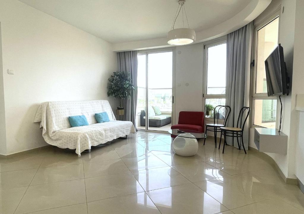 ein weißes Schlafzimmer mit einem Bett und einem Esszimmer in der Unterkunft 2BR VACATION HOME EILAT in Eilat