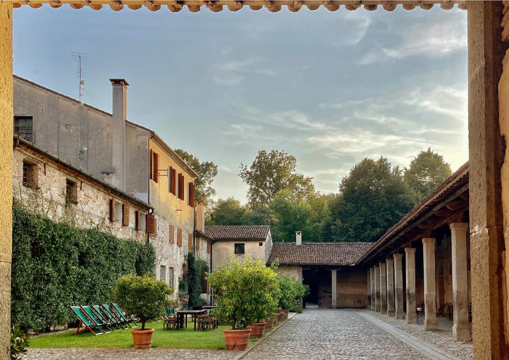 a courtyard of an old building with chairs and trees at Frassanelle in Rovolon