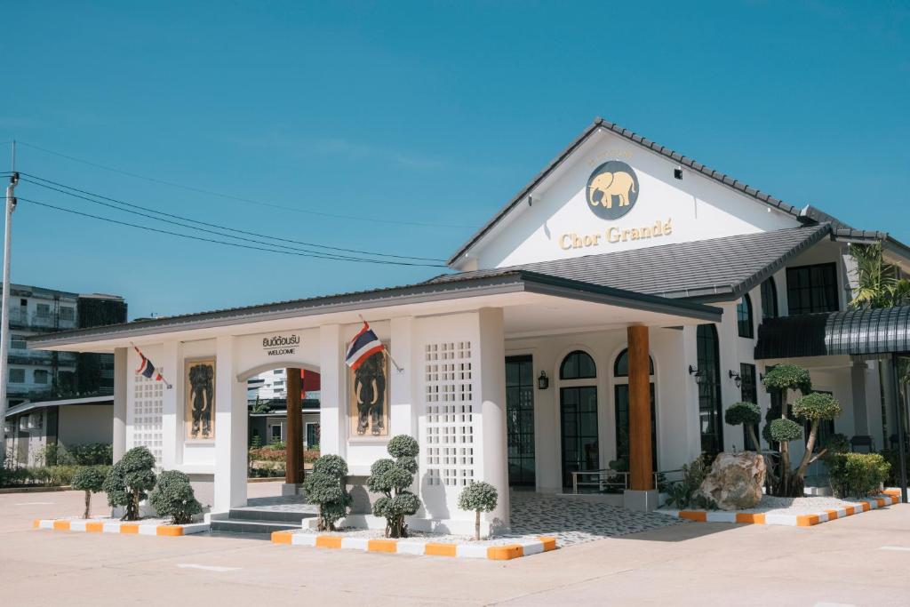 a white building with a sign on it at Chor Grande Resort in Trat