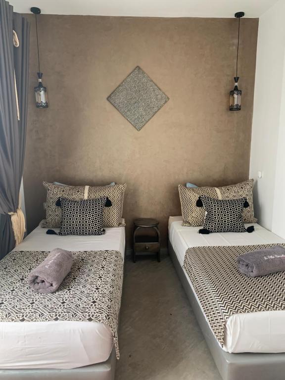 a bedroom with two beds with pillows on them at RIAD LE PATIO ROMANTIQUE in Marrakesh
