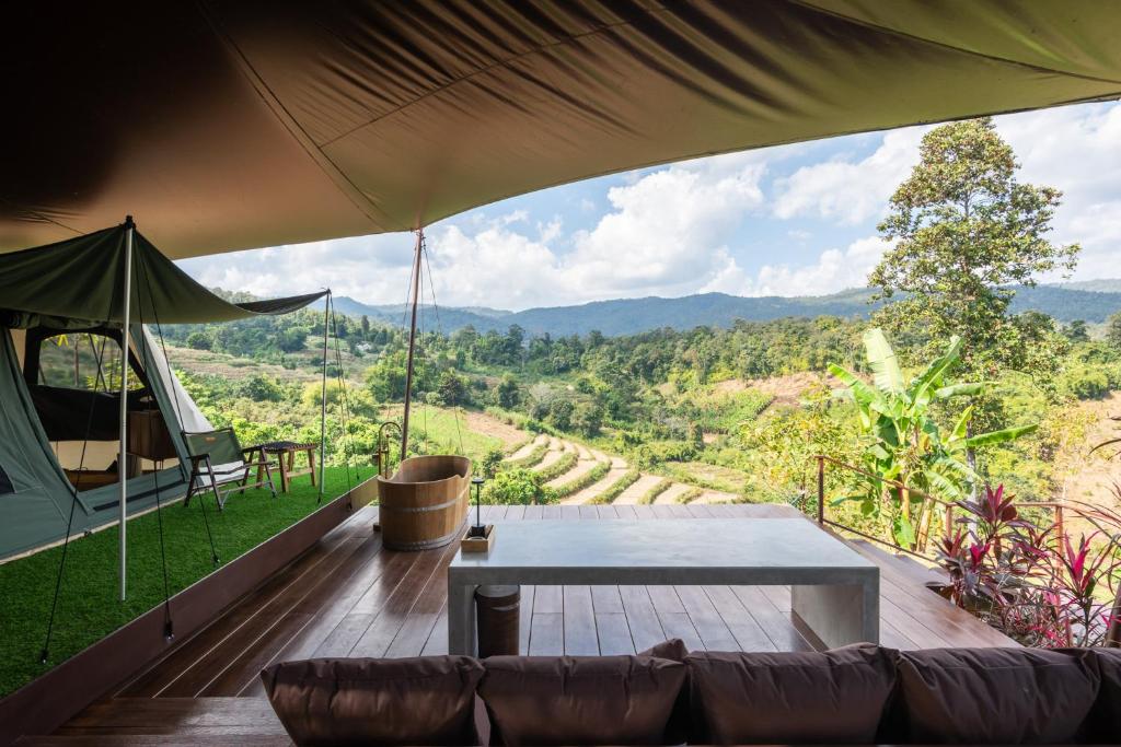 Aussicht vom Wohnzimmer eines Zeltes mit einem Tisch in der Unterkunft CAMP CAYLA - STELLAR in Chiang Mai