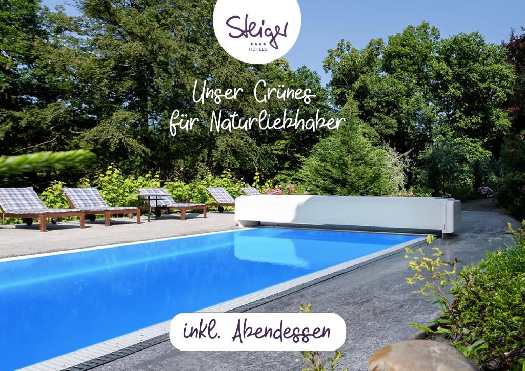 una piscina en un patio con un cartel que dice que es más sabio vivir para los constructores naturales en STEIGER Parkhotel Hohnstein en Bad Schandau