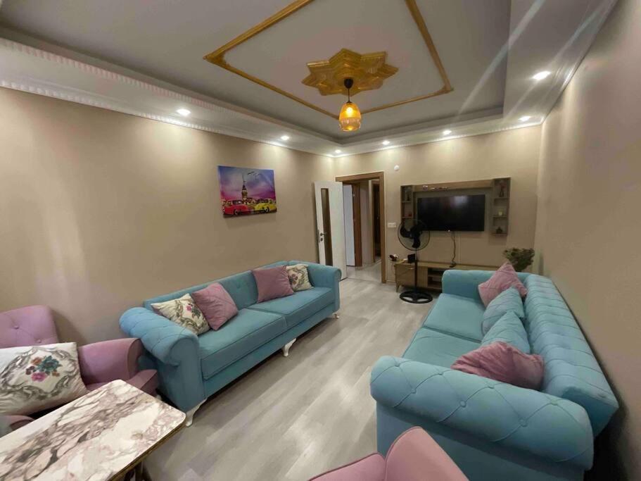 ein Wohnzimmer mit 2 blauen Sofas und einem TV in der Unterkunft شقة مريحة مناسبة للعائلة 1 Comfortable apartment suitable for family in Esenyurt