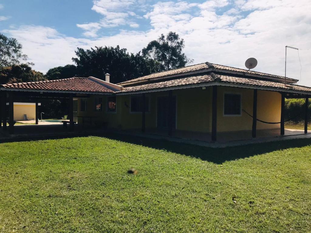 una pequeña casa con un patio de hierba delante de ella en Chacara R. da Felicidade proximo ao thermas, aguas de sao pedro en Águas de São Pedro