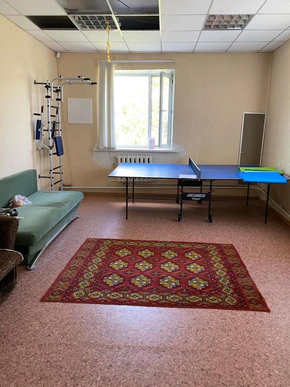a room with two tables and a rug on the floor at Фермерское хозяйство in Karagandy