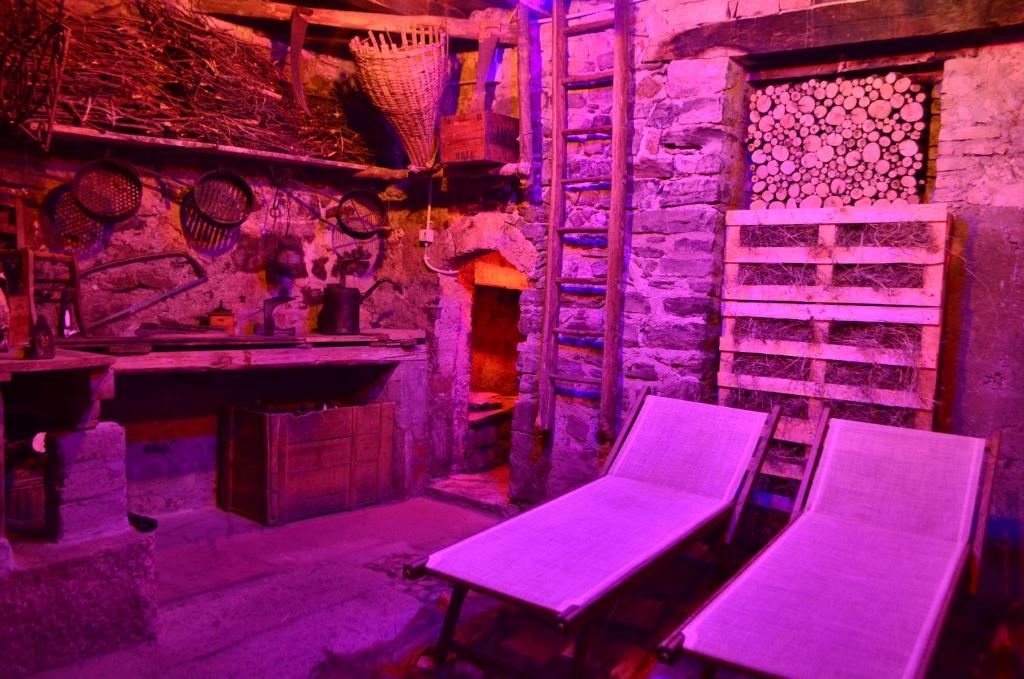 due sedie e un tavolo in una stanza con illuminazione viola di Casa Adriana a Oria