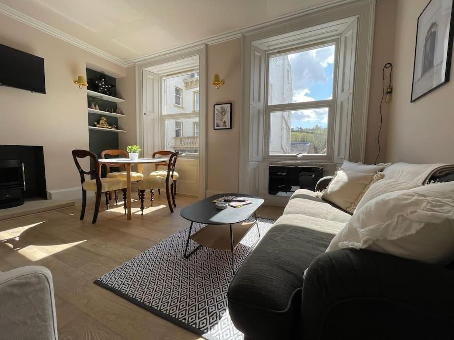 uma sala de estar com um sofá e uma mesa em Bijou apartment in the heart of Melrose em Melrose
