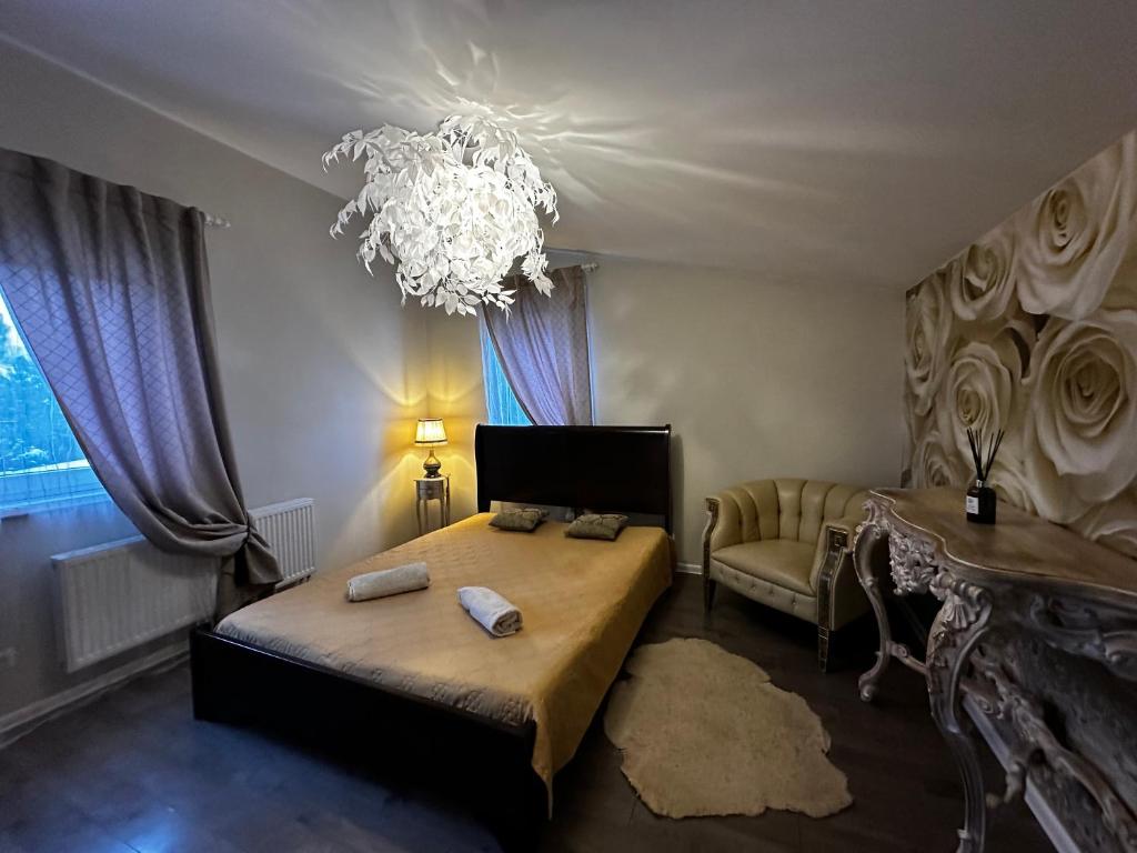 a bedroom with a large bed and a chandelier at Cosy apartment in Kaunas