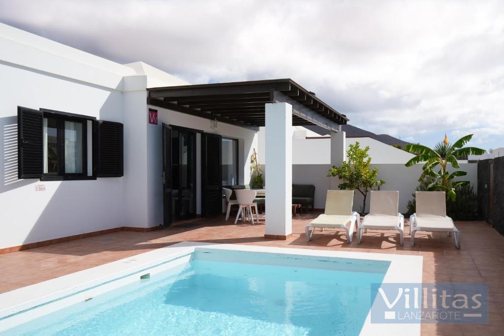 a swimming pool in front of a house at VILLA BERMEJA 20 by Villitas in Playa Blanca