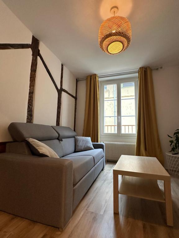een woonkamer met een bank en een tafel bij Au colombage de Chalon, centre ville quartier historique in Chalon-sur-Saône