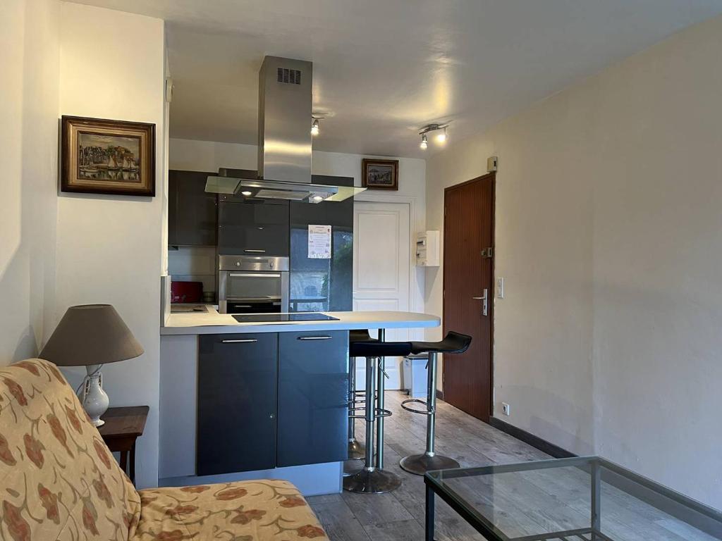 eine Küche mit einer blauen Insel in einem Raum in der Unterkunft 656 - Charmant studio à Erquy, situé à environ 100m du centre 300m de la plage in Erquy