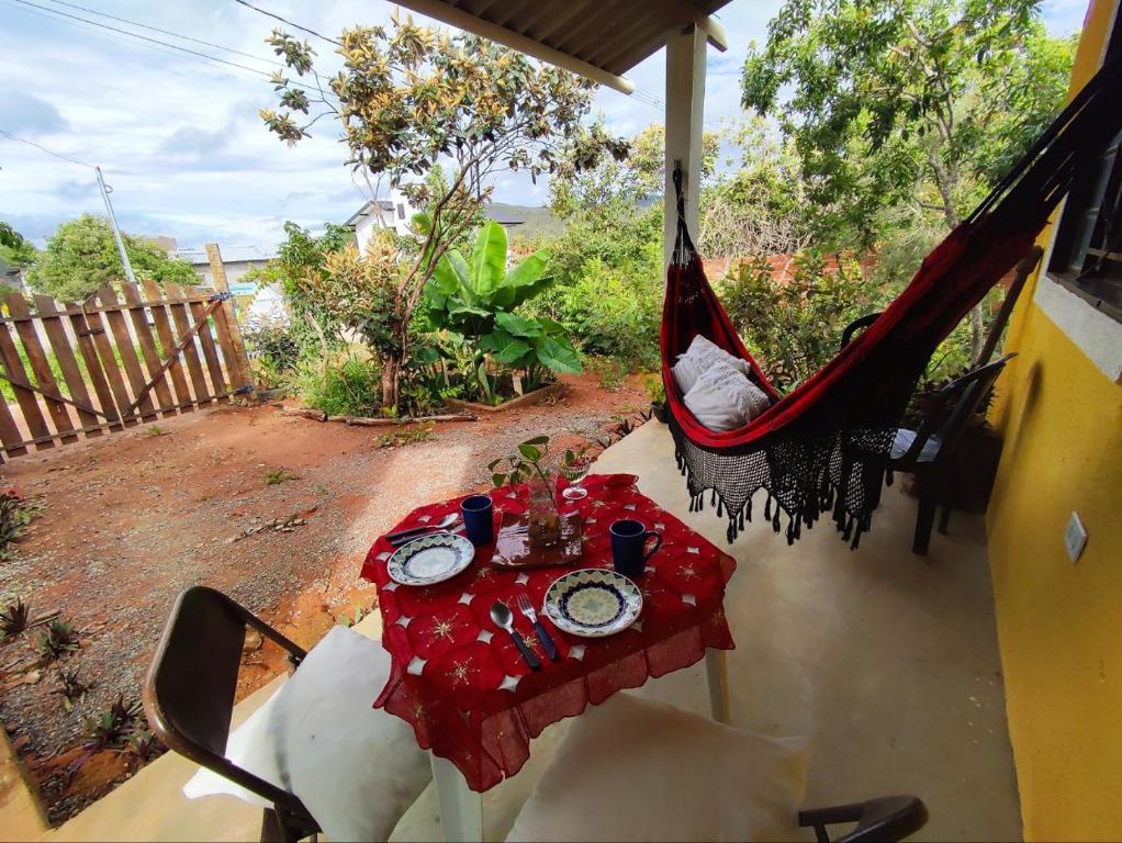 een tafel in een hangmat op een veranda bij Chalé dos Lírios in Alto Paraíso de Goiás