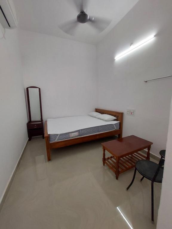 a room with a bed and a table and a chair at Hill house in Tiruvannāmalai