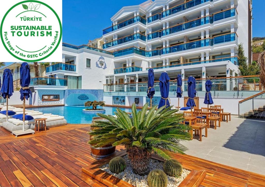 a hotel with blue umbrellas and a swimming pool at Meis Exclusive Hotel in Kaş
