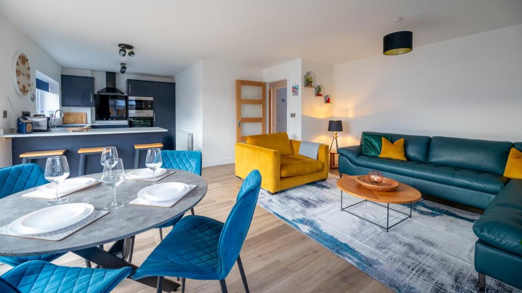 uma sala de estar com um sofá azul e uma mesa e cadeiras em The Beach House with Balcony North Wales em Kinmel Bay
