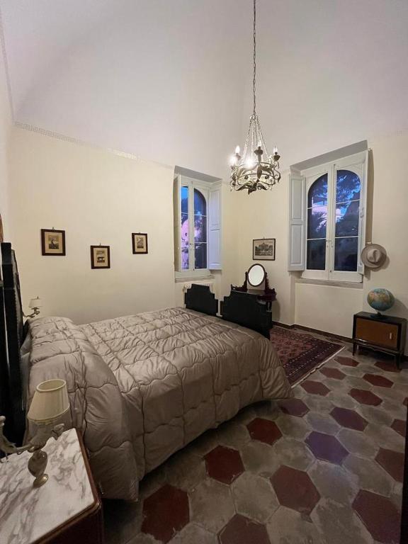 sypialnia z łóżkiem i żyrandolem w obiekcie Villa Giada w mieście Trani