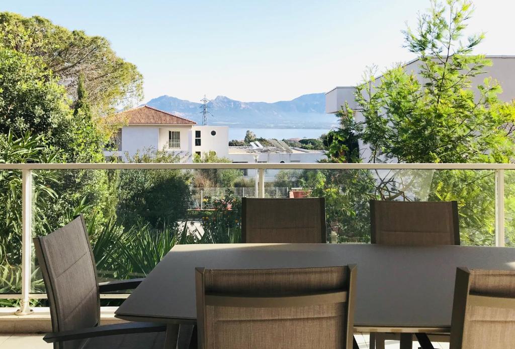 une table et des chaises sur un balcon avec vue dans l'établissement Appartement Les terrasses Calvi, à Calvi